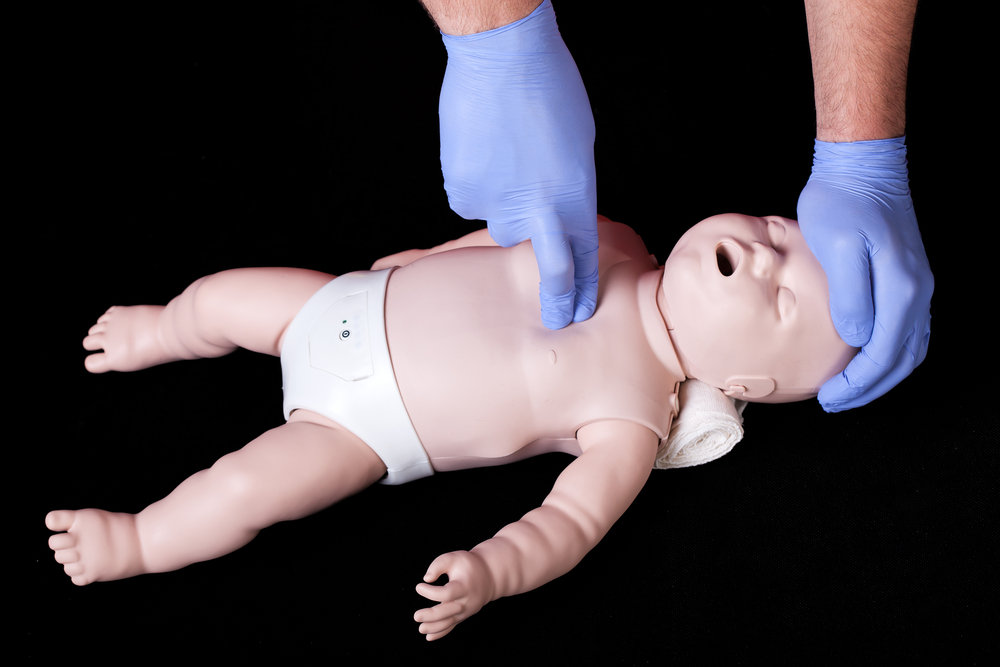 A student practising resuscitation on a plastic baby phantom